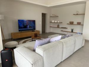 a living room with a white couch and a tv at SANTOSHA in Tamarin