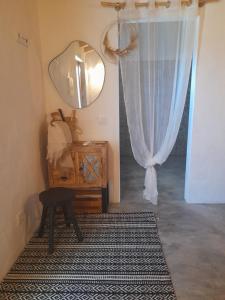 a room with a mirror and a table and a rug at Natur Amêndoa 