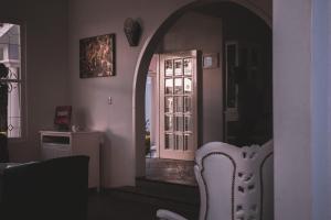 a dining room with an archway and a white chair at Casa Bonita Hotel & Luxury Residence in Oaxaca City