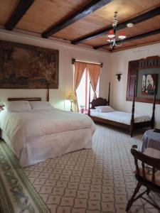 a bedroom with two beds and a large window at Casona Patrimonial Cobquecura Hotel Boutique in Cobquecura