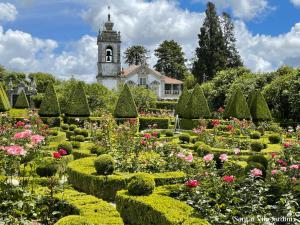 ein Garten mit einem Uhrturm im Hintergrund in der Unterkunft Casa Poesia - Santar in Santar