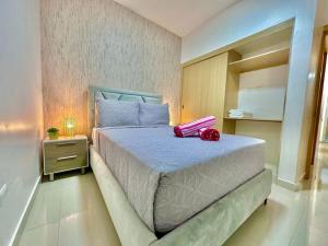 Un dormitorio con una cama con una bolsa rosa. en Cozy Hideaway Apt Near Beach en Boca Chica