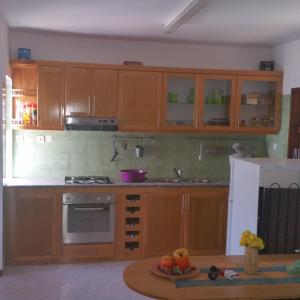 a kitchen with wooden cabinets and a table in a room at Beach Villa with pool in Mindelo