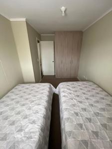 two beds in a small room with at Casa Nueva 3 dormitorios 2B in Puerto Montt