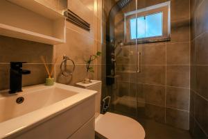 a bathroom with a toilet and a sink and a shower at Gold Coast Photography Inn in Estoril