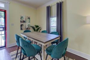 uma sala de jantar com uma mesa de madeira e cadeiras verdes em Bright & Charming Cooper Young Cottage with Fire Pit and Porch Swing em Memphis
