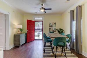 une salle à manger avec une porte rouge, une table et des chaises dans l'établissement Bright & Charming Cooper Young Cottage with Fire Pit and Porch Swing, à Memphis