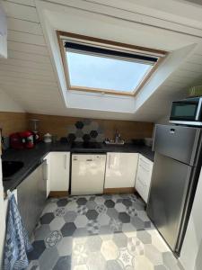 a small kitchen with a skylight in the ceiling with a kitchenestamp at Séjour idyllique in Annecy