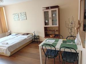 a bedroom with a bed and a table and chairs at Green belt apartmann in Budapest