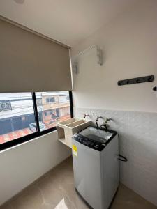 a kitchen with a small refrigerator and a window at Mar Apartamentos in Bucaramanga