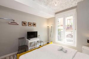 a bedroom with a bed and a tv and a window at The Hipstel Parallel in Barcelona