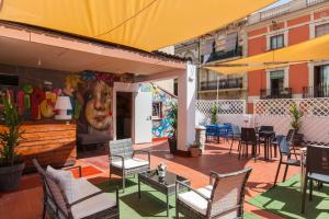 un patio con sillas, mesas y un mural en The Hipstel Parallel, en Barcelona