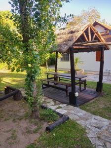 einem hölzernen Picknicktisch mit Strohdach in der Unterkunft 4 SOLES in Villa Gesell