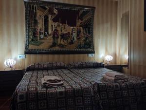 um quarto com uma cama com uma fotografia na parede em Casa Rural Cueva El Sauce em Pegalajar