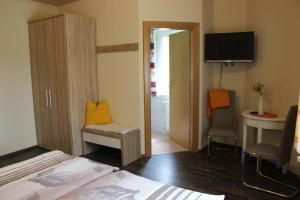 a bedroom with a bed and a bathroom with a television at Gasthof Pension Jägerwirt in Velden am Wörthersee