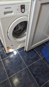 uma máquina de lavar roupa com a porta aberta numa cozinha em Guest house 
