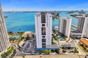 uma vista aérea de um edifício branco alto junto à água em A Wave From It All! Direct water views! em Miami