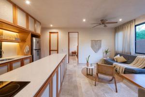 a kitchen and a living room with a couch at Nibana departamento de lujo en Mérida, Planta baja in Mérida