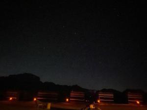 a starry sky with two american flags in the dark at Wadi rum secrets camp in Wadi Rum
