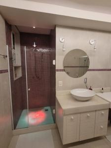 a bathroom with a shower and a sink and a mirror at Apê Turquesa, 190 m da praia do Leme in Rio de Janeiro