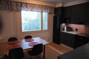 a kitchen with a table and chairs and a window at Apartment for six near Railway station in Rovaniemi