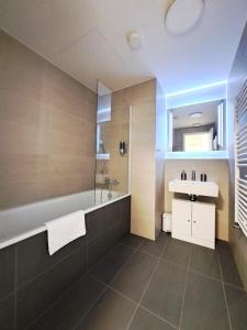 a bathroom with a tub and a sink at Prestigious SKY PARK apartment - City view - Traveller awards 2024 in Bratislava