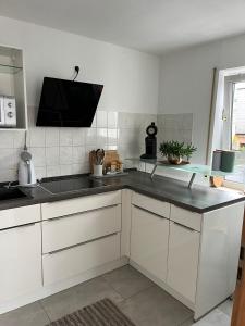 a kitchen with white cabinets and a black counter top at Ferienwohnung Milla in Weissach Im Tal
