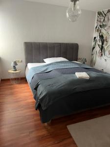 a bedroom with a large bed with a gray headboard at Ferienwohnung Milla in Weissach Im Tal