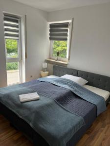 a bedroom with a large blue bed with two windows at Ferienwohnung Milla in Weissach Im Tal