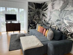 a living room with a blue couch with colorful pillows at Ferienwohnung Milla in Weissach Im Tal