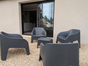 een groep stoelen voor een gebouw bij Rez de jardin proche de la mer in Arradon