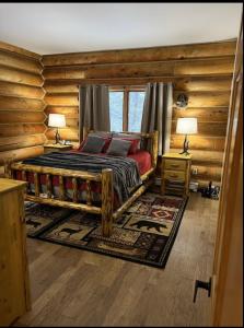 1 dormitorio con 1 cama en una cabaña de madera en Cerul Mare Cabin en Gallatin Gateway