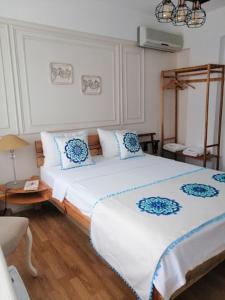 een slaapkamer met een bed met witte en blauwe kussens bij Sığacık Duru Pansiyon in Seferihisar