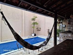 eine Hängematte auf einer Terrasse neben einem Pool in der Unterkunft Casa de temporada Uberaba piscina in Uberaba