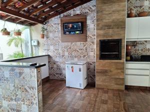 a kitchen with a refrigerator and a tv on the wall at Casa de temporada Uberaba piscina in Uberaba