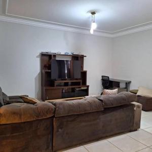 a living room with a couch and a flat screen tv at Casa de temporada Uberaba piscina in Uberaba