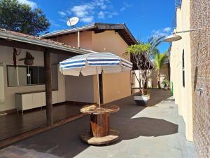 a patio with an umbrella and a table at Casa de temporada Uberaba piscina in Uberaba