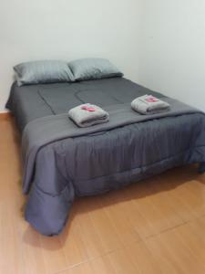 Una cama con dos toallas encima. en HOSTEL RESIDENCIAL SAENZ PEÑA en Sáenz Peña