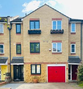 a brick house with red doors and windows at Riverside Studio Apartment Docklands E14 in London