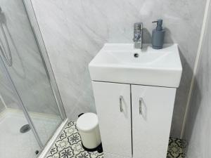 a bathroom with a white sink and a shower at Riverside Studio Apartment Docklands E14 in London