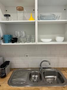 a kitchen sink with plates and glasses on a shelf at Near Monsanto W/ Barbecue in Lisbon