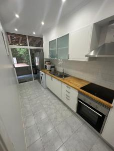 a large kitchen with white cabinets and a sink at Near Monsanto W/ Barbecue in Lisbon