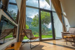 a room with a view of the mountains through windows at North Alpine Villas in Bogë