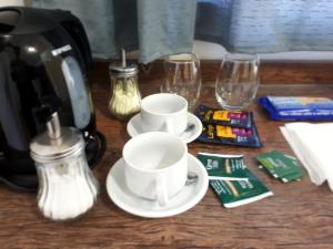 a table with two cups and glasses and a coffee maker at HOSTEL RESIDENCIAL SAENZ PEÑA in Sáenz Peña