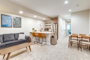 ein Wohnzimmer und eine Küche mit einem Sofa und einem Tisch in der Unterkunft Cozy Denver Vacation Rental Near Broncos Stadium! in Denver