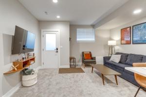 ein Wohnzimmer mit einem blauen Sofa und einem TV in der Unterkunft Cozy Denver Vacation Rental Near Broncos Stadium! in Denver