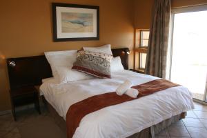 A bed or beds in a room at Namib Naukluft Lodge