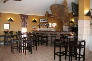 bar z czarnymi stołkami w restauracji w obiekcie Namib Naukluft Lodge w mieście Solitaire