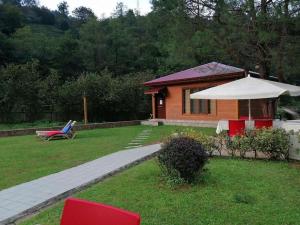 una pequeña casa en un patio con un banco y una sombrilla en Trabzon Karadeniz Uzungol, en Bodrum City