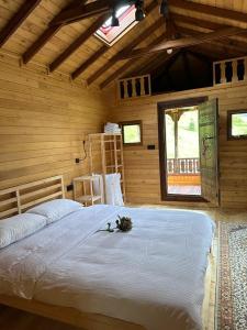 ein Schlafzimmer mit einem großen Bett in einem Holzzimmer in der Unterkunft House Nero in Tonya